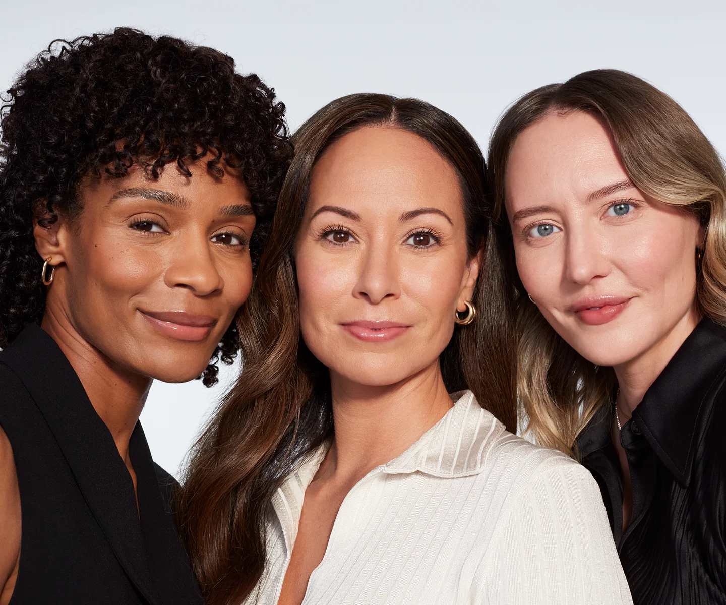 Three women with different skin types smiling