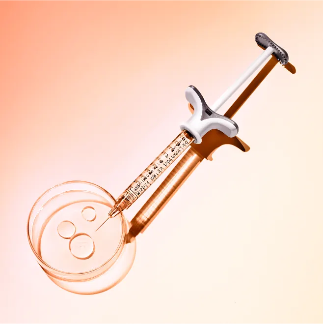 A needle pointing vertically down going into a petri dish