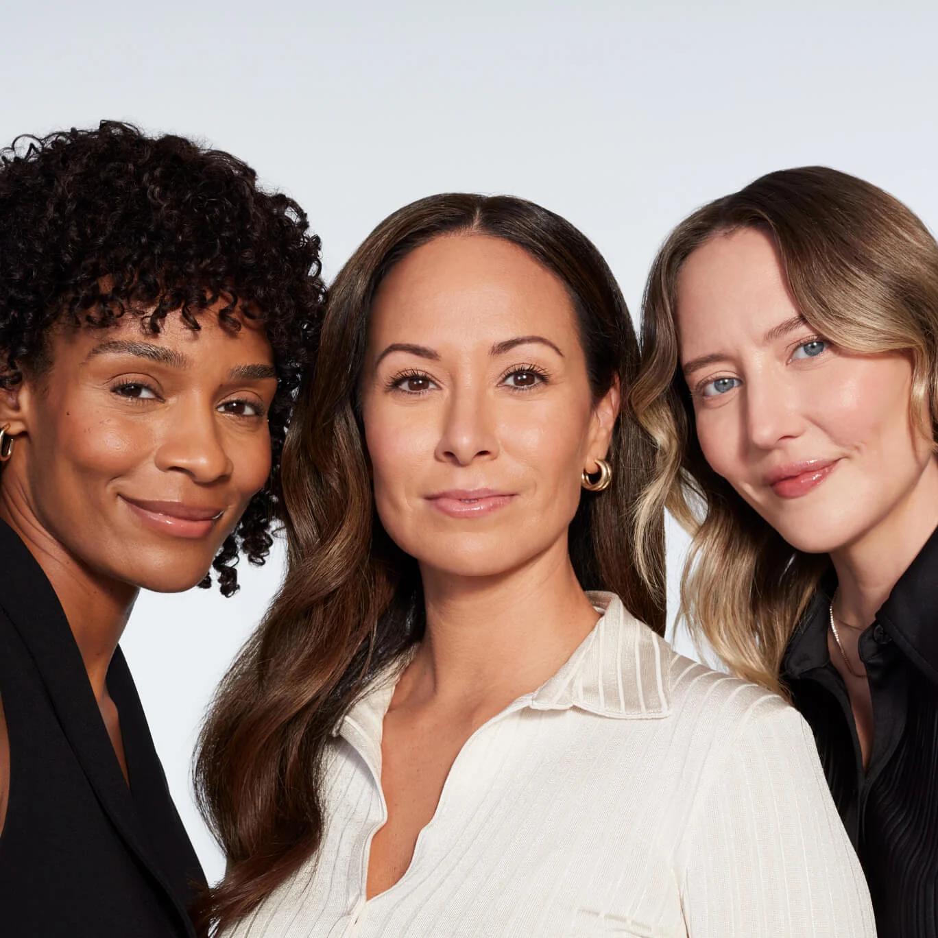 Three woman looking at a camera, smiling
